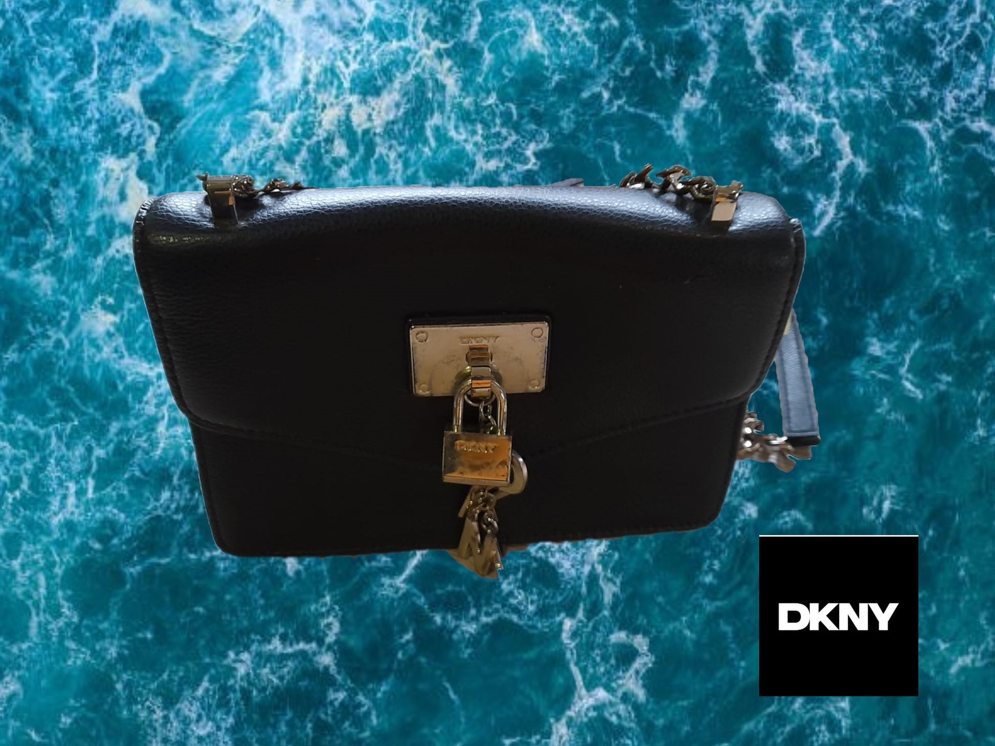 BOLSO PEQUEÑO NEGRO PIEL CON LETRAS EN FORMA LLAVERO Y CANDADO DKNY ( TARA ROCE PARTE DELANTERA Y METAL DEFECTUOSO )