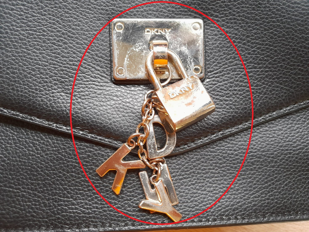 BOLSO PEQUEÑO NEGRO PIEL CON LETRAS EN FORMA LLAVERO Y CANDADO DKNY ( TARA ROCE PARTE DELANTERA Y METAL DEFECTUOSO )