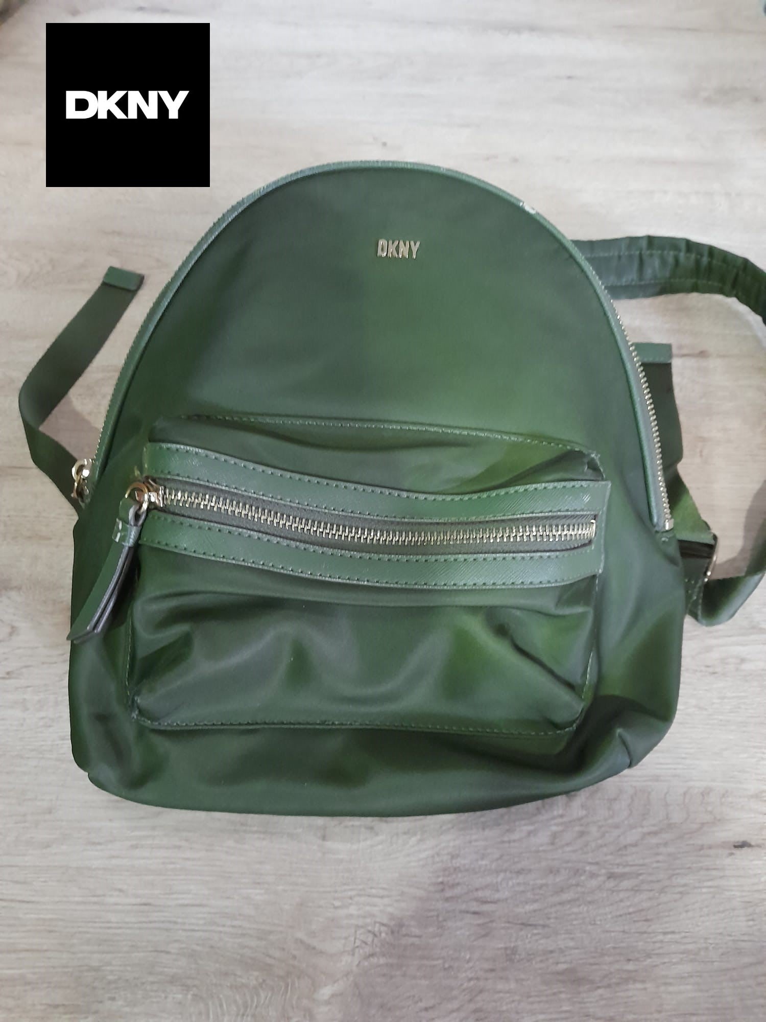 MOCHILA VERDE TELA DKNY ( TARA PEQUEÑA MARCHA EN PARTE SUPERIOR Y MANCHA EN PARTE BAJA )