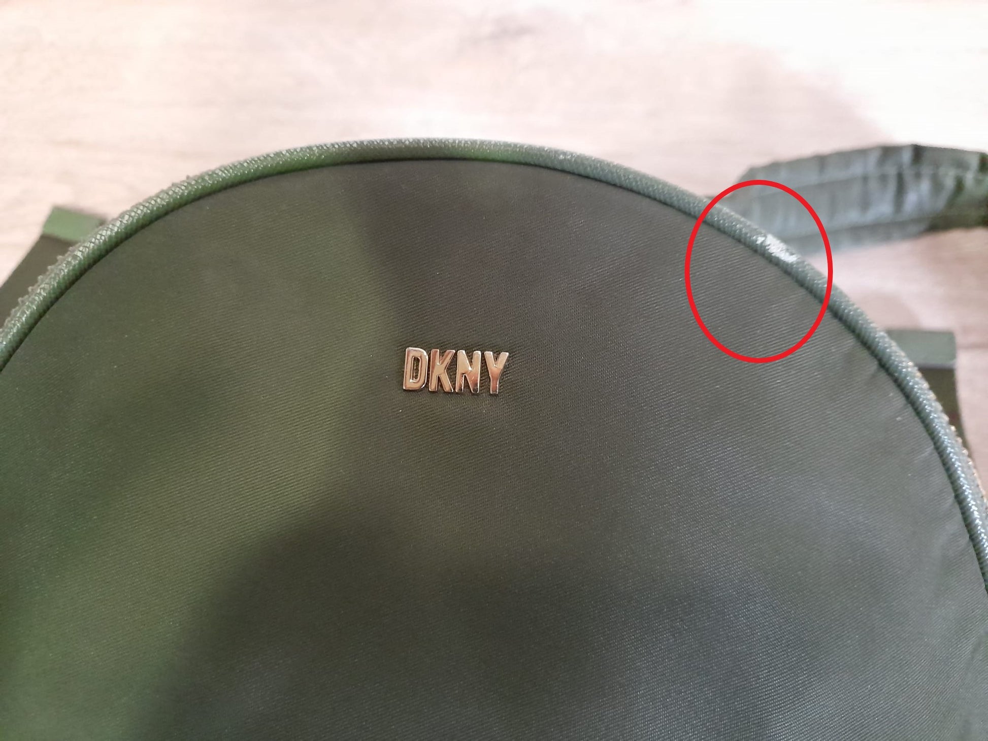 MOCHILA VERDE TELA DKNY ( TARA PEQUEÑA MARCHA EN PARTE SUPERIOR Y MANCHA EN PARTE BAJA )