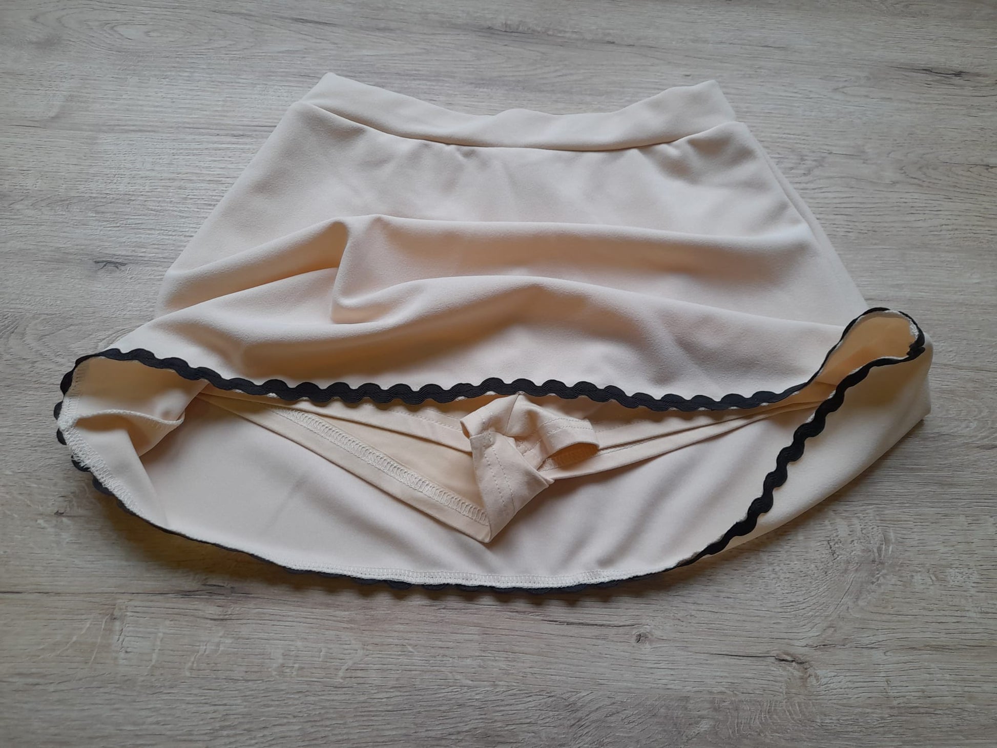 FALDA-PANTALÓN BEIGE ROSADO CORTA CON RIBETE NEGRO