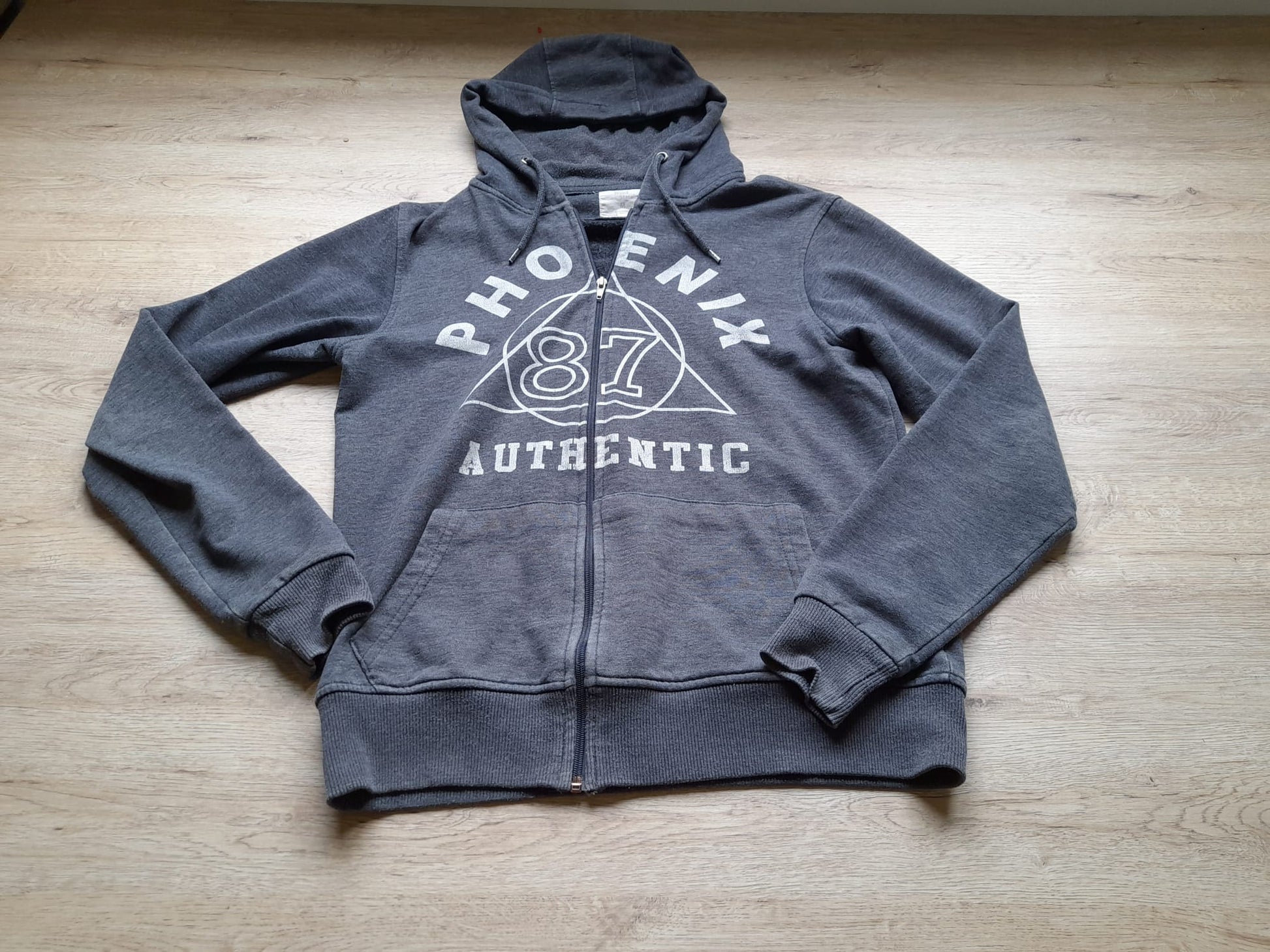 SUDADERA GRIS CON CAPUCHA Y LOGO EN EL PECHO