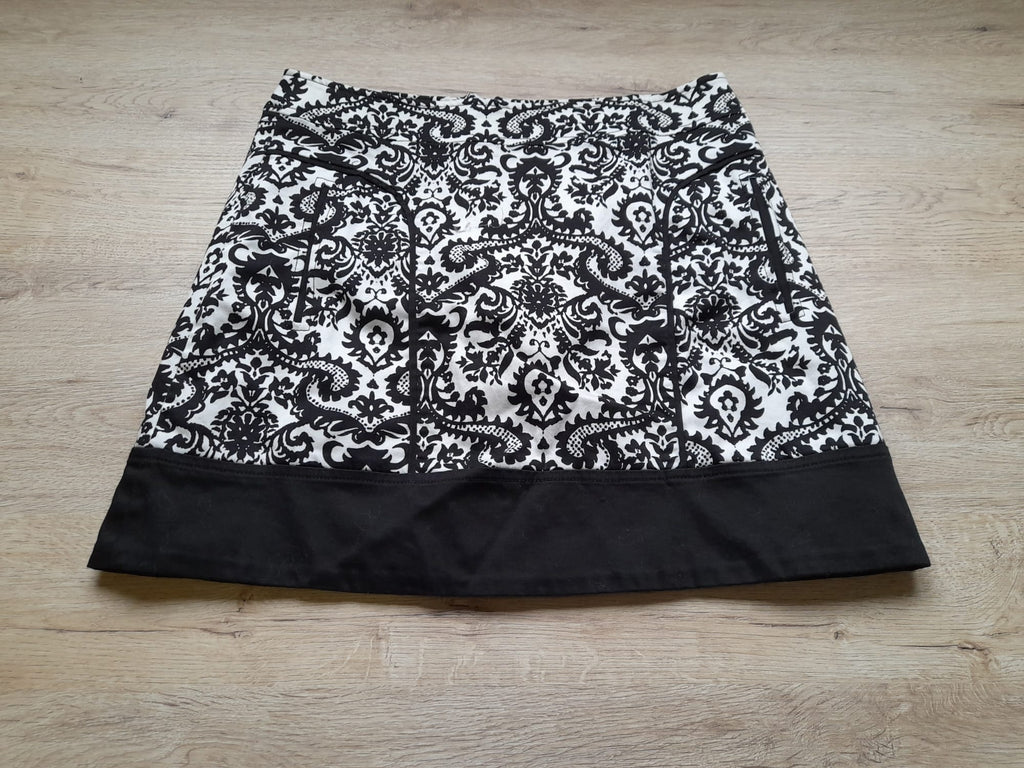 MINI FALDA BLANCA CON ESTAMPADO FLORAL NEGRO Y CIERRE DE CREMALLERA