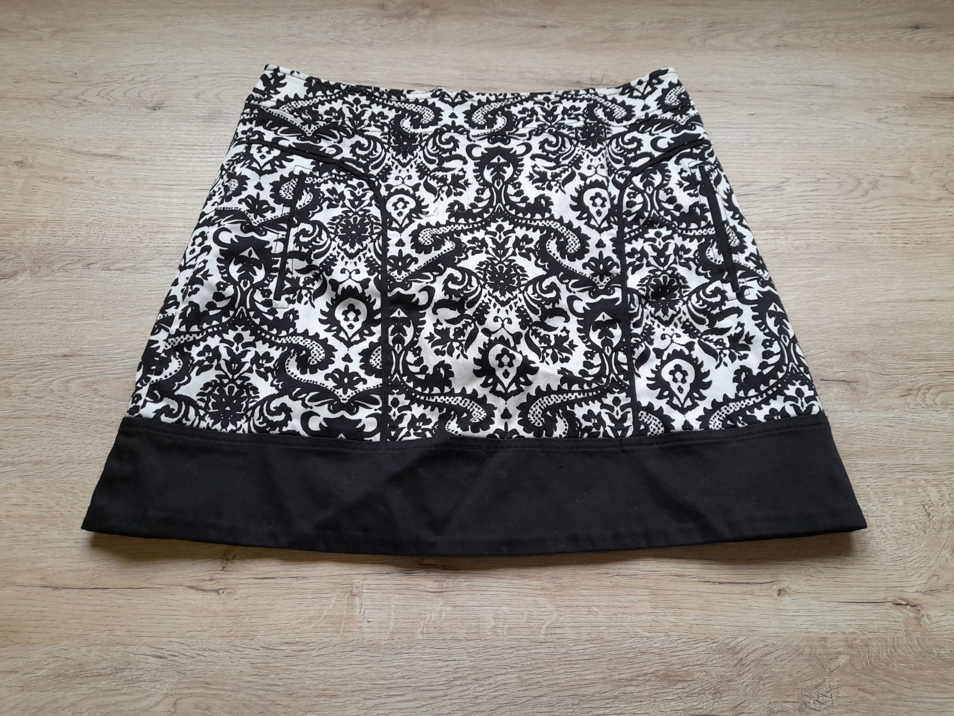 MINI FALDA BLANCA CON ESTAMPADO FLORAL NEGRO Y CIERRE DE CREMALLERA