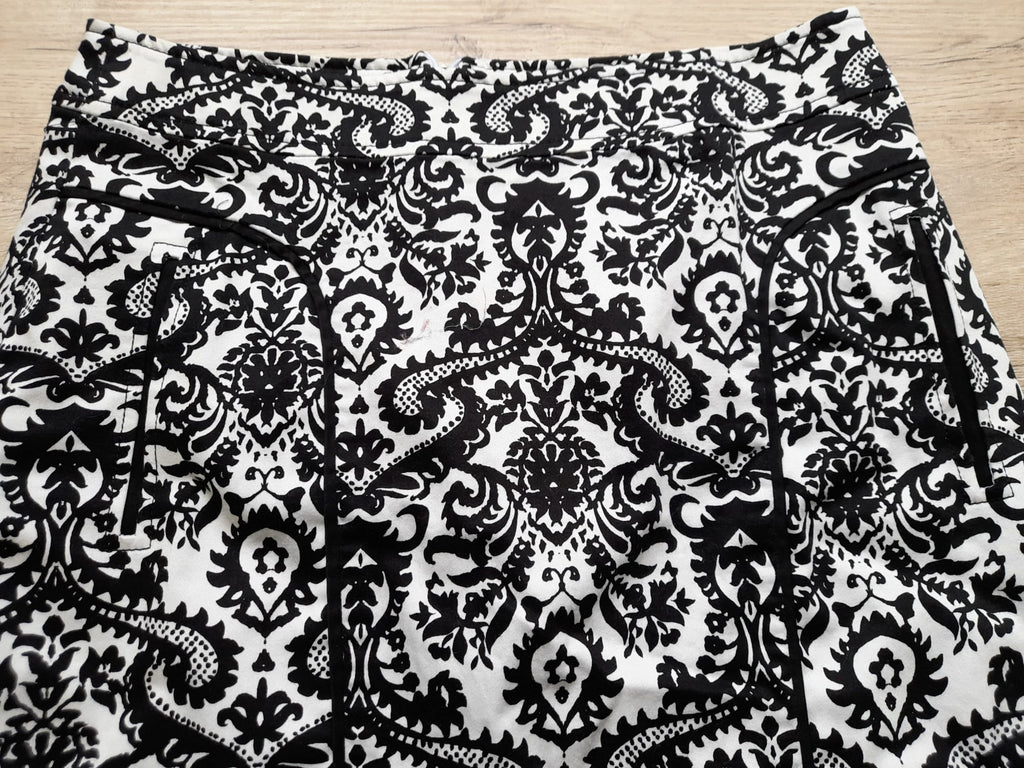 MINI FALDA BLANCA CON ESTAMPADO FLORAL NEGRO Y CIERRE DE CREMALLERA