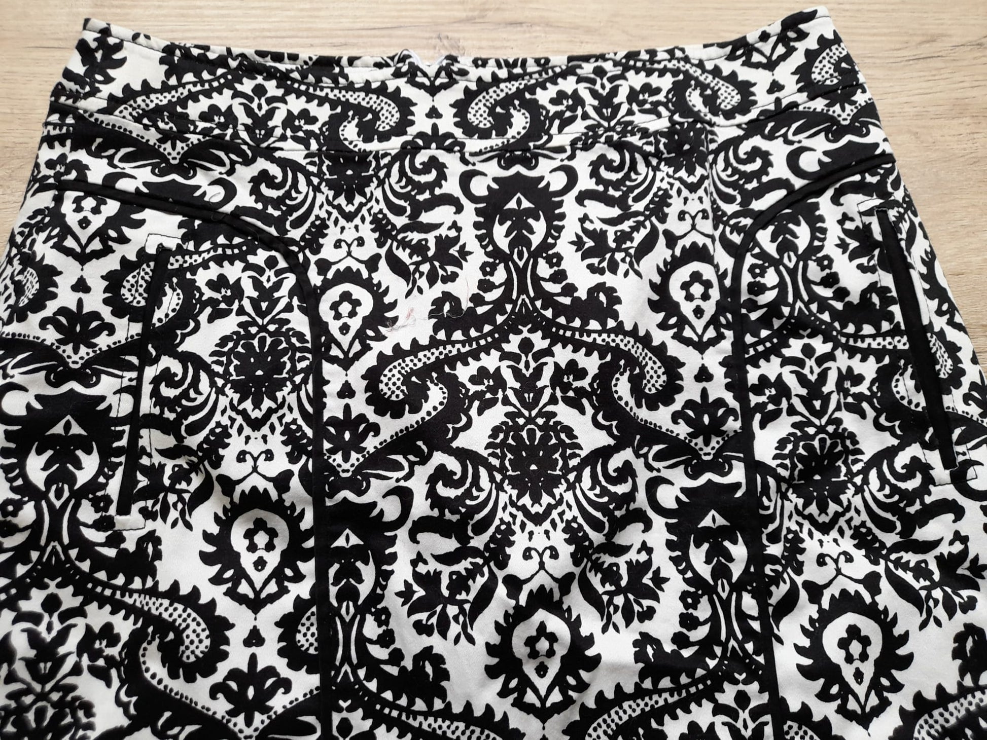 MINI FALDA BLANCA CON ESTAMPADO FLORAL NEGRO Y CIERRE DE CREMALLERA