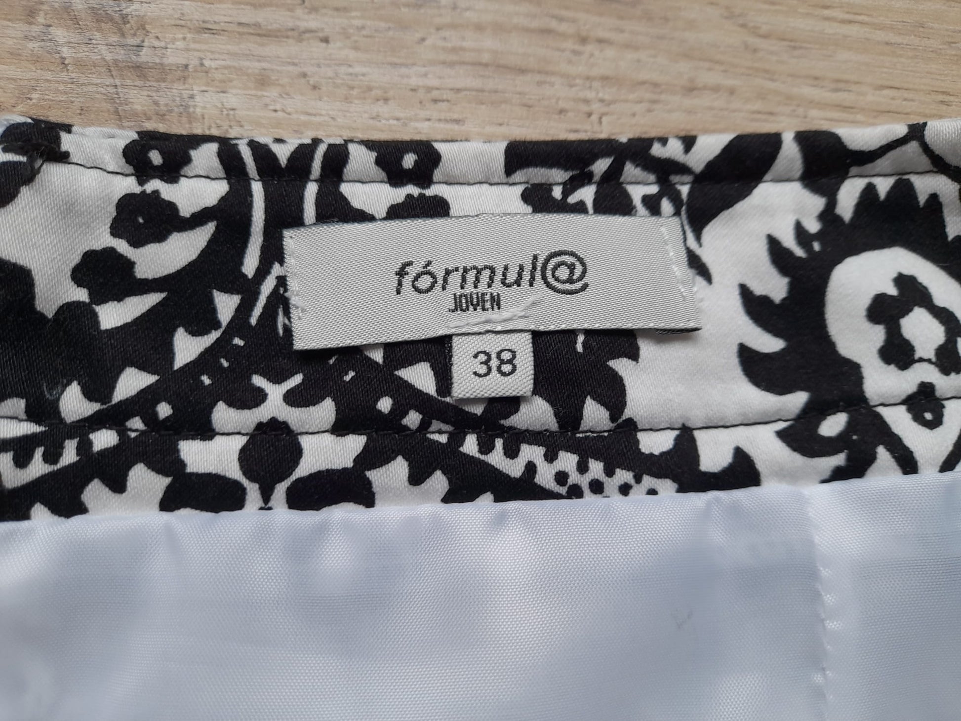 MINI FALDA BLANCA CON ESTAMPADO FLORAL NEGRO Y CIERRE DE CREMALLERA