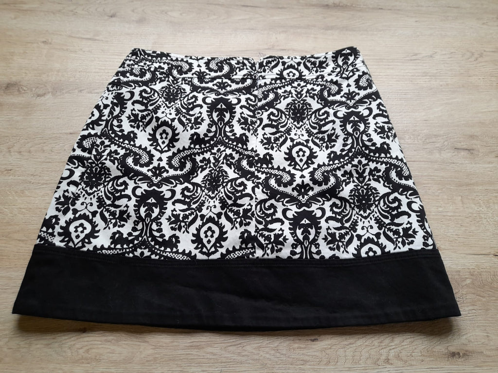 MINI FALDA BLANCA CON ESTAMPADO FLORAL NEGRO Y CIERRE DE CREMALLERA