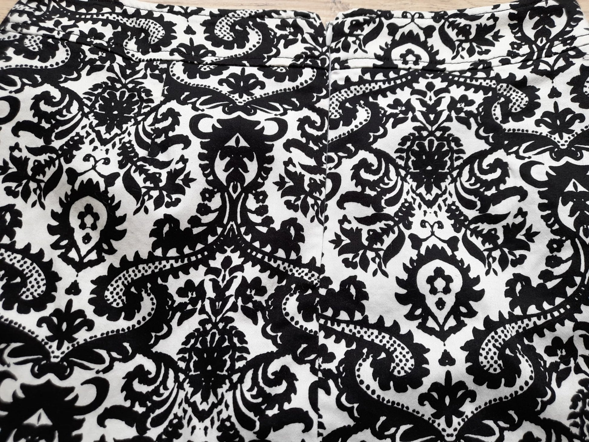 MINI FALDA BLANCA CON ESTAMPADO FLORAL NEGRO Y CIERRE DE CREMALLERA