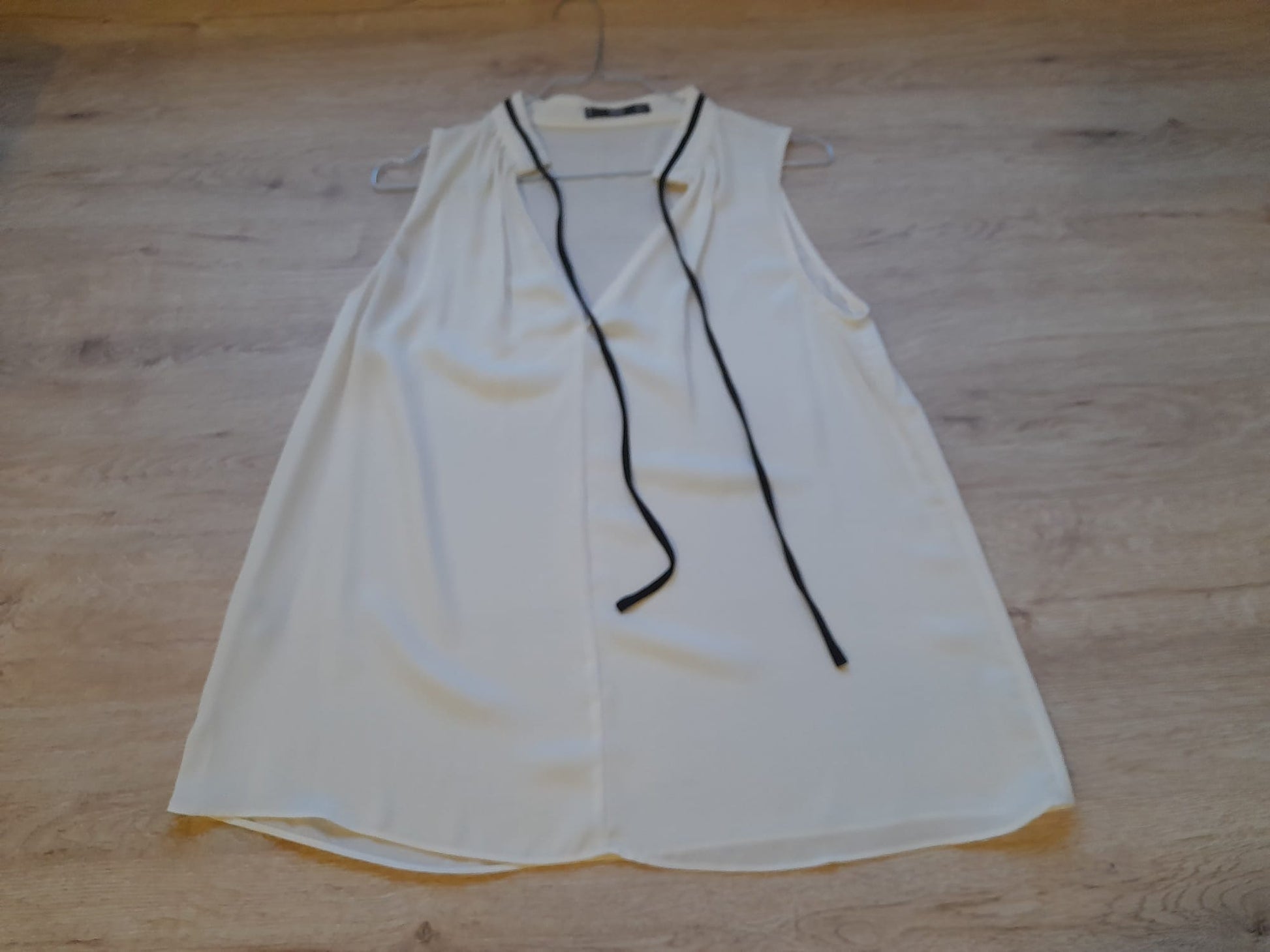 BLUSA BLANCA SIN MANGAS CON DETALLE LAZO PARA CUELLO