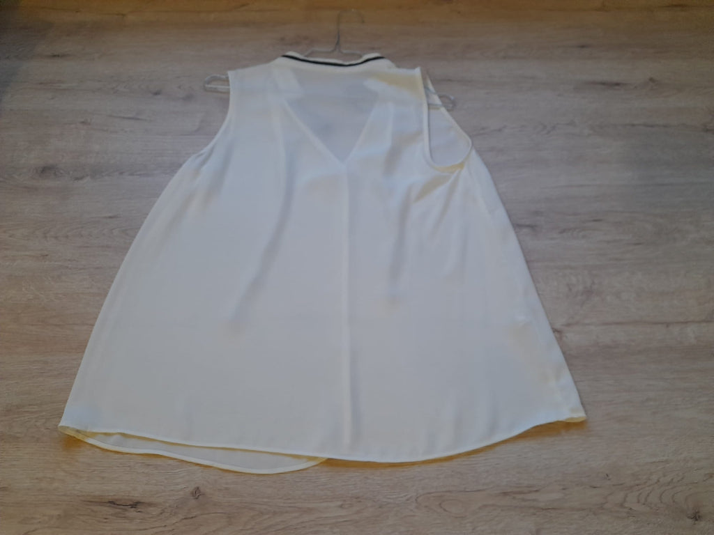 BLUSA BLANCA SIN MANGAS CON DETALLE LAZO PARA CUELLO